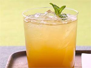 Glass of iced tea or lemonade with mint garnish and ice cubes.