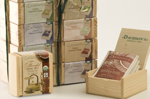 Stacked decorative tea boxes and an open wooden box with tea bags.